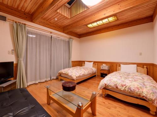 武雄市北方温泉四季の里　七彩の湯的一间带两张床和电视的客厅