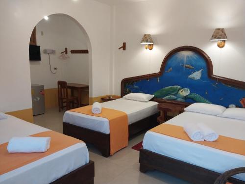 比亚米尔港La Casa de Joel的酒店客房设有三张床,墙上挂有绘画作品