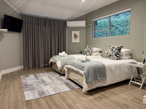 鲁德普特Serene Place Guest House & Conference Venue AFFORDABLE LUXURY WITH BACKUP POWER的一间卧室配有两张床和电视。