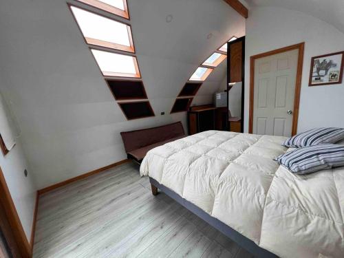 库里科Casa Rural Curicó - Apartamentos的一间卧室设有一张大床和天窗。