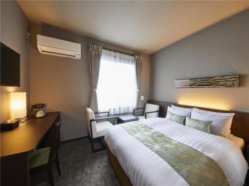 京都若平安白川酒店　Waka Heian Shirakawa Hotel的配有一张床、一张书桌和一扇窗户的酒店客房
