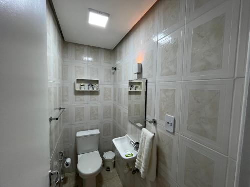 瓜拉久巴Guarajuba, Duplex pé na areia. Ótima localização!的白色的浴室设有卫生间和水槽。