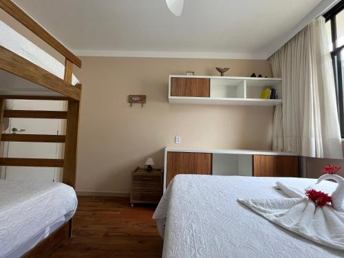 瓜拉久巴Guarajuba, Duplex pé na areia. Ótima localização!的一间卧室配有两张床和一张双层床。