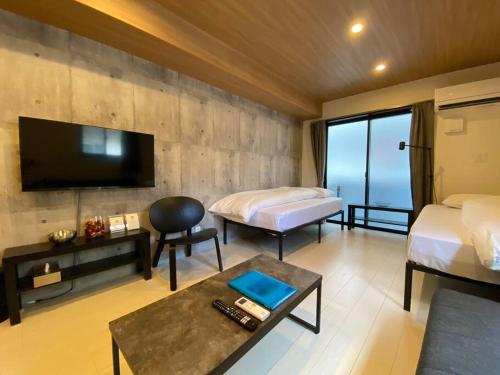 熊本リブレ in Kumamoto 201的酒店客房设有两张床和一台平面电视。