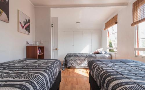 圣地亚哥Casa Fuerteventura的一间卧室设有两张床和窗户。
