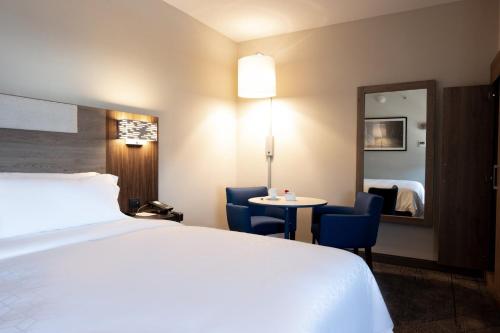 墨西哥城Holiday Inn Express Mexico City Satelite, an IHG Hotel的酒店客房配有床、桌子和镜子