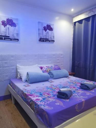 阿尔坎塔拉Dew Forest - Romblon Airport Hotel的一间卧室配有一张大床和紫色棉被