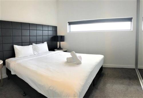悉尼Serain Residences on 88 Archer Chatswood的卧室内的一张大白色床,带有窗户
