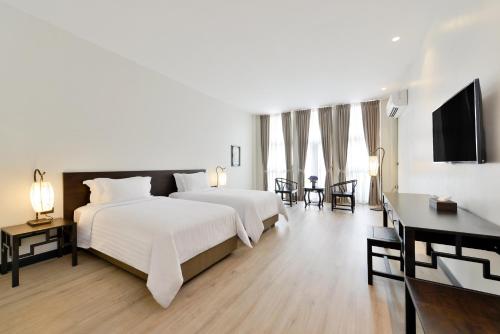 曼谷Oldthaiheng Hotel的卧室配有一张白色大床和电视。