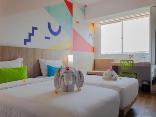 金巴兰祖里吉姆巴兰快捷旅馆的一间房间,配有两张床,上面放着大象