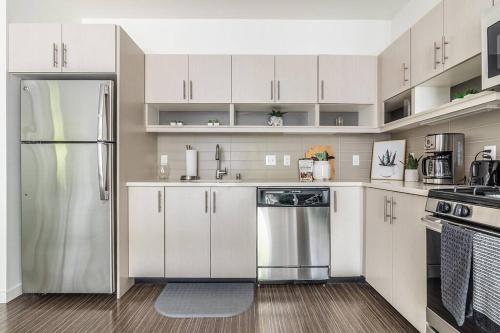 西雅图One bedroom luxury apartment (Gym, Wifi, Parking, Rooftop Deck)的厨房配有白色橱柜和不锈钢冰箱