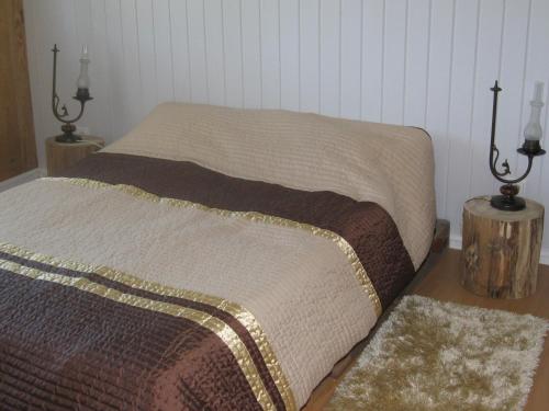 蓬蒂-达巴尔卡Casa Do Pinheiral的卧室内的一张床位,配有两盏灯和两块地毯