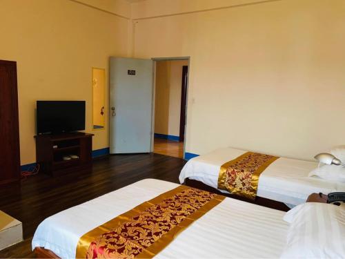 科洛尼亚CHINA STAR HOTEL的酒店客房设有两张床和一台平面电视。