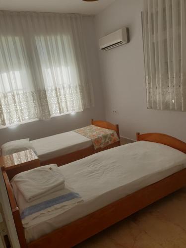 安塔利亚Beldibi Apart Homes的卧室设有两张单人床和窗户。