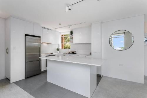 悉尼HAR20 - 2 bedroom Harrison Street - Cremorne的白色的厨房配有水槽和镜子