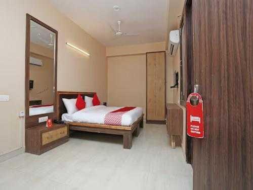 加济阿巴德OYO Flagship Grand Aashirwad的一间卧室配有红色枕头的床