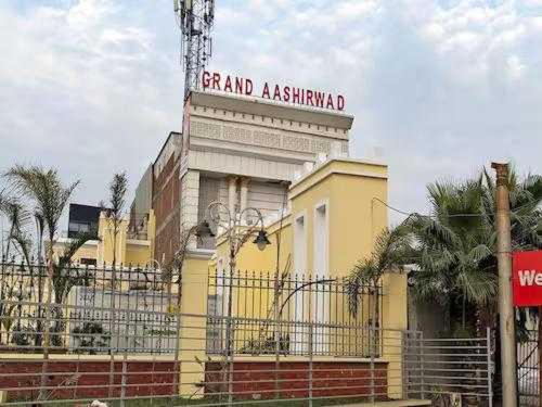 加济阿巴德OYO Flagship Grand Aashirwad的黄色的建筑,上面有标志