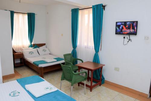 姆特瓦帕Greenyard Resort Mtwapa的客房设有两张床、一张桌子和一张沙发。