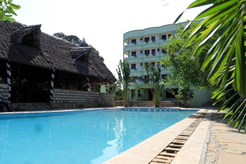 姆特瓦帕Greenyard Resort Mtwapa的大楼前的游泳池