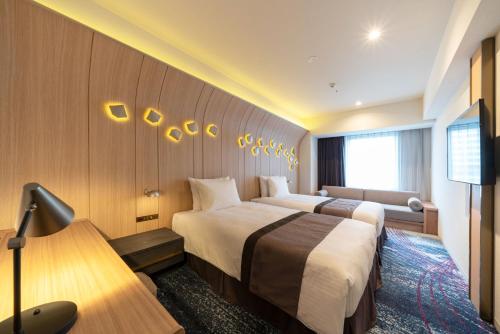 名古屋Hotel JAL City Nagoya Nishiki的酒店客房设有两张床和电视。