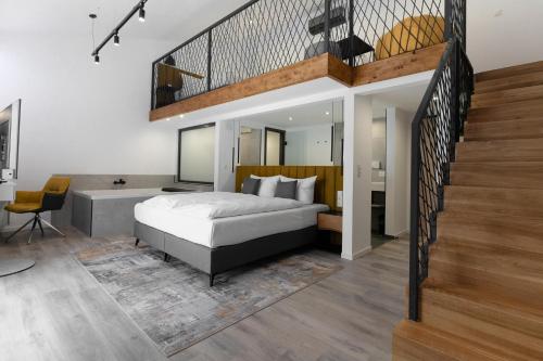 鲁斯特Hotel Andante Rust的一间带大床和楼梯的卧室