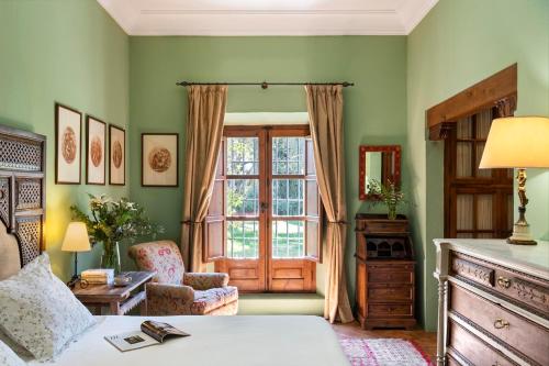 梅里那德奥拉菲Hacienda el Burgo的绿色的客房设有床和窗户。