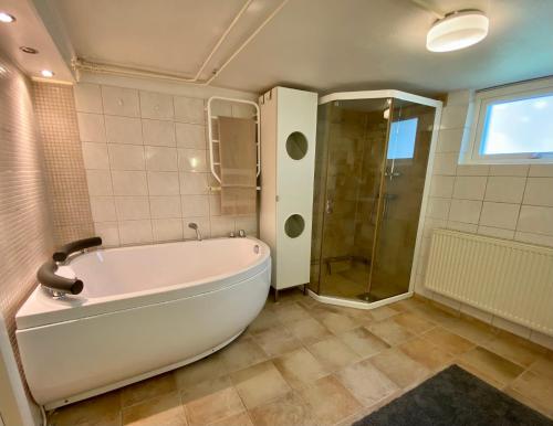 斯德哥尔摩Lower floor of 50 sqm in nice villa with parking的一间带大浴缸和淋浴的浴室