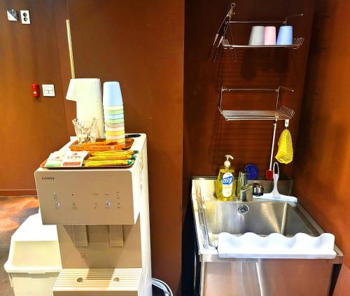 首尔Good Guesthouse的厨房配有水槽和柜台旁的搅拌机
