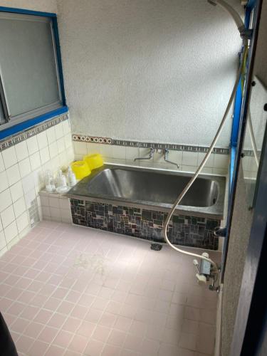 大岛素泊まり民宿とみや的浴室配有盥洗盆和浴缸。
