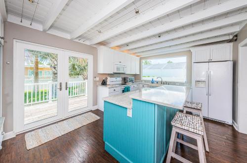 圣徒皮特海滩Hummingbird Hideaway的厨房配有蓝色橱柜和白色冰箱
