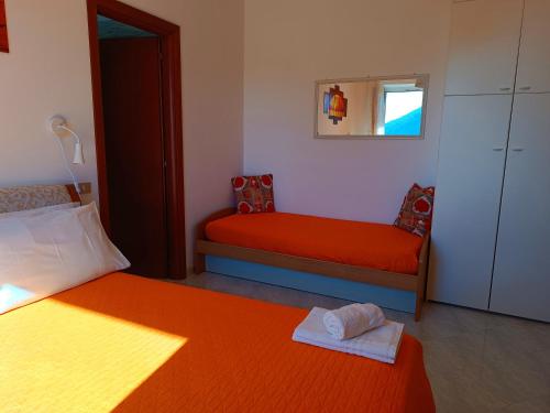 维耶特里La Roccia Incantata Amalfi Coast的一间卧室配有两张带橙色床单和镜子的床