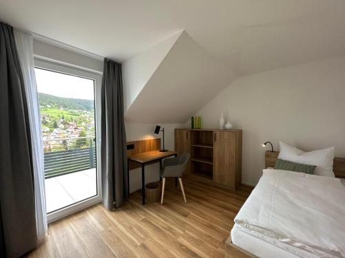 拜尔斯布龙Ferienhaus Waldschatz Baiersbronn的一间卧室配有一张床和一张带窗户的书桌