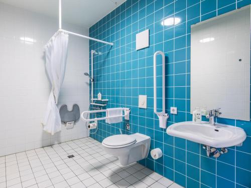罗森海姆罗森海姆酒店的蓝色瓷砖浴室设有卫生间和水槽