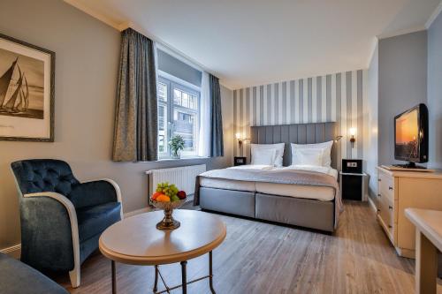 韦斯特兰Sylthotel Raffelhüschen Garni的酒店客房配有一张床铺和一张桌子。