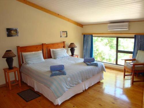 索德瓦纳湾Reefteach Lodge的一间卧室配有一张大床和两张蓝色椅子