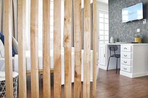 波尔图Oporto Sweet Downtown 5的卧室设有木隔板、书桌和床。