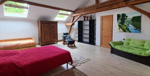 Saint-NaborGrange Des Arts的一间卧室配有一张床和一张绿色沙发