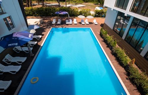 谢赫维蒂利Buxus Villas Shekvetili的享有带椅子和遮阳伞的游泳池的上方景色