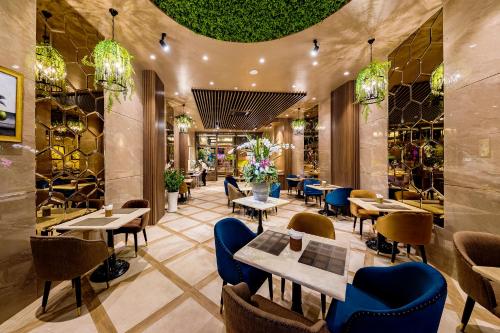 胡志明市Sunflower Luxury Hotel的一间带桌椅和天花板的餐厅
