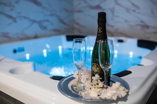 奥古林Klečka vila B&B rooms的浴缸内的桌子上放有一瓶香槟和两杯酒