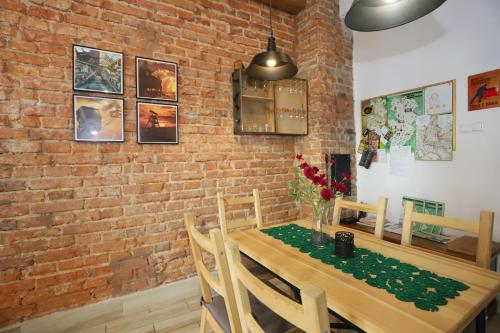 瓦乌布日赫Apartament Gwarek的一间设有砖墙和木桌的用餐室