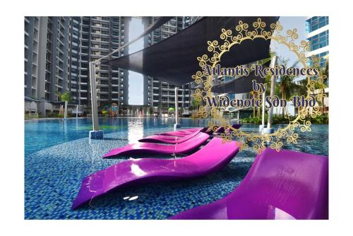 马六甲Atlantis Residence - Widenote Sdn Bhd的游泳池里一排紫色椅子
