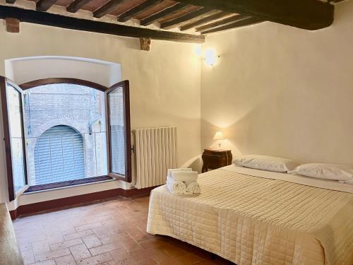 锡耶纳Franciosa Lodge - Cattedrale的一间卧室设有一张床和一个大窗户