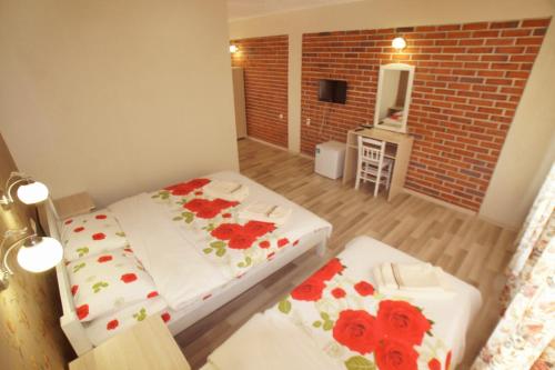 KrumovgradHotel Divna的小房间设有两张床和砖墙