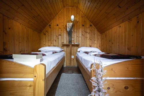 圣格奥尔基海豚露营酒店的木制客房内设有两张单人床,