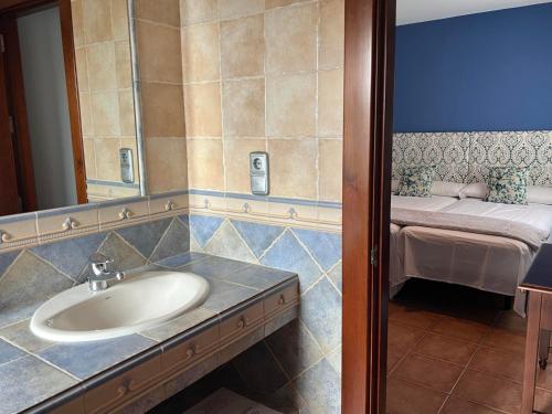 厄尔埃基多HOSTAL TREVELEZ的一间带水槽和镜子的浴室以及一张床