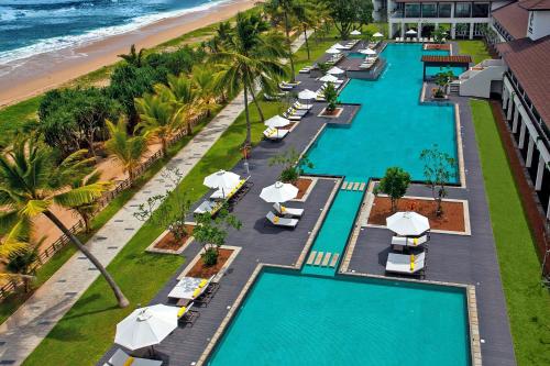 本托塔Centara Ceysands Resort & Spa Sri Lanka的享有海滩上的泳池空中景致