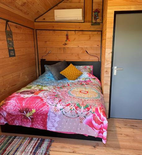 SwalmenHoogte Huisje Fantasie的小木屋内一间卧室,配有一张床