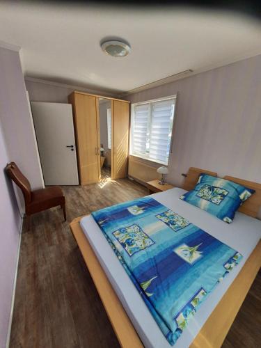 LathenFerienwohnung 24 Unten Rechts 3 Zimmer的一间卧室配有一张带蓝色毯子的大床