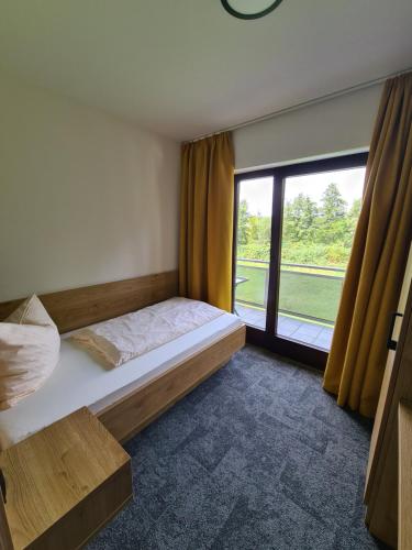 罗德高Gästehaus Weber的一间卧室设有一张床和一个大窗户